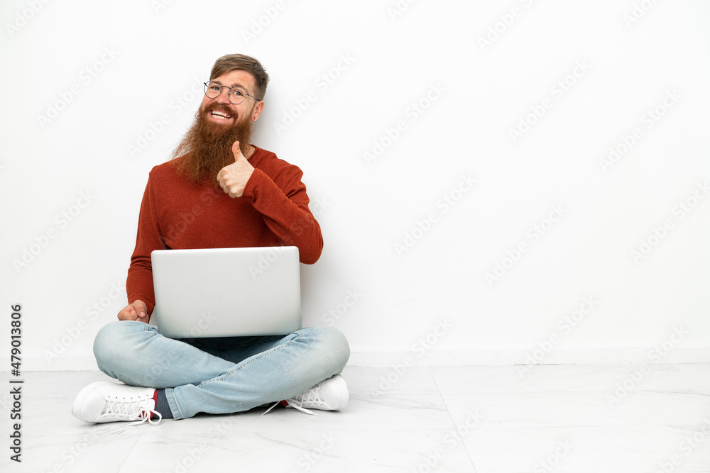 Young reddish caucasian man with laptop isolated on white background giving a thumbs up gesture Young reddish caucasian man with laptop isolated on white background giving a thumbs up gesture
