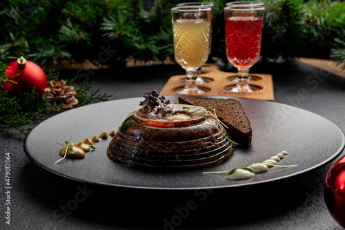 aspic served with black bread on a dark plate with mustard and horseradish on a dark Christmas background photo