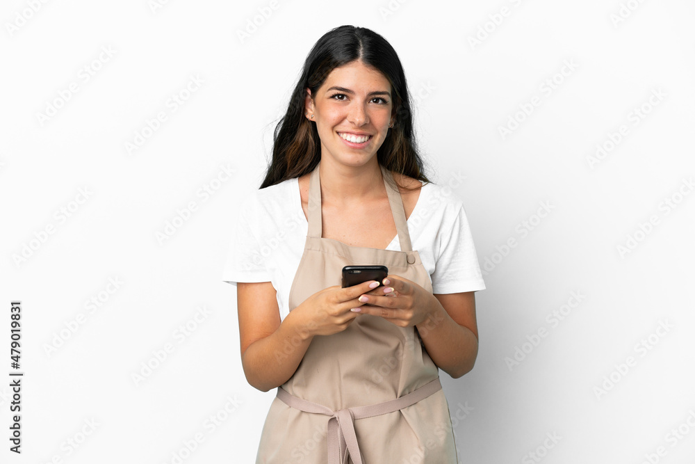 Restaurant waiter over isolated white background sending a message with the mobile Restaurant waiter over isolated white background sending a message with the mobile