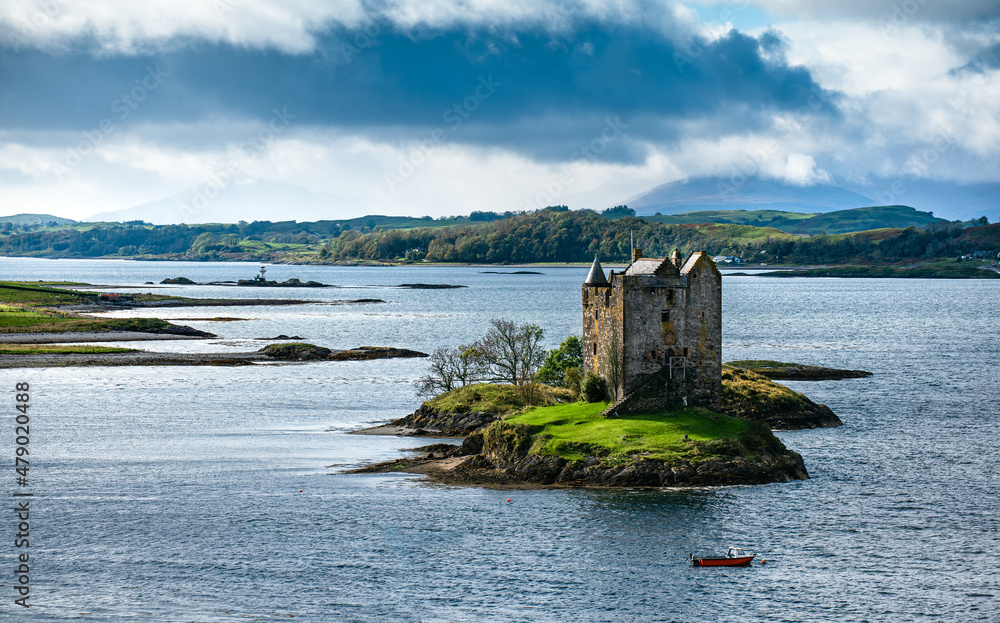 Castle Stalker, Argyll, Scotland. Summer View with blue skies and golden light. Clear view along the Sea Loch.