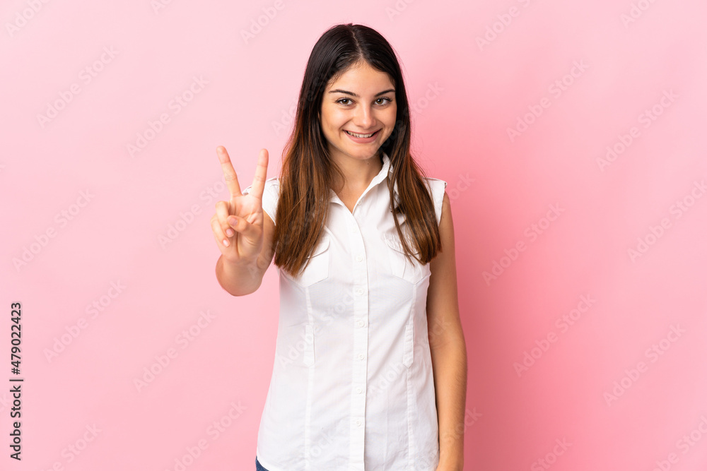 Young caucasian woman isolated on pink background smiling and showing victory sign Young caucasian woman isolated on pink background smiling and showing victory sign