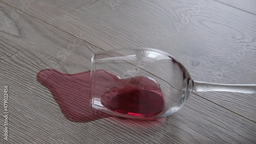 a glass of wine is lying on the floor. Wine spilled