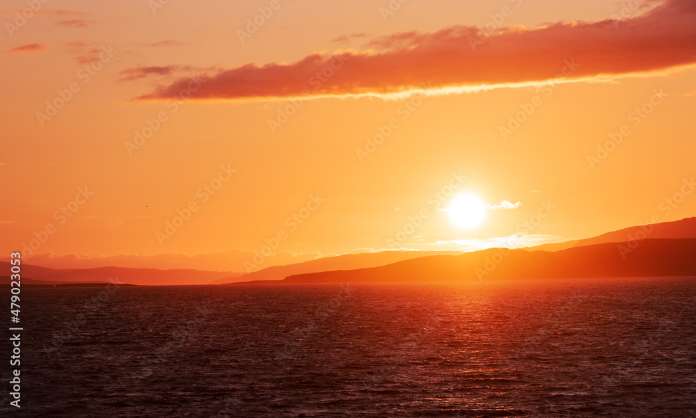Sea sunset with clear view of sun and glow on the sea surface.