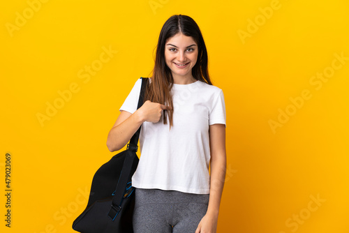 Young sport woman with sport bag isolated on yellow background with surprise facial expression © luismolinero