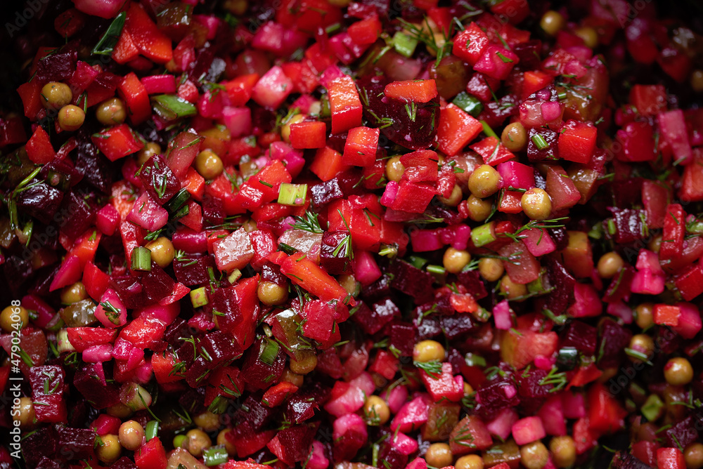 Traditional Russian ukrainian vegetable salad with beetroot vinaigrette. Vegan cuisine. salad with boiled vegetables pickled cucumber, carrots, peas, sauerkraut. Food background. Home kitchen Traditional Russian ukrainian vegetable salad with beetroot vinaigrette. Vegan cuisine. salad with boiled vegetables pickled cucumber, carrots, peas, sauerkraut. Food background. Home kitchen