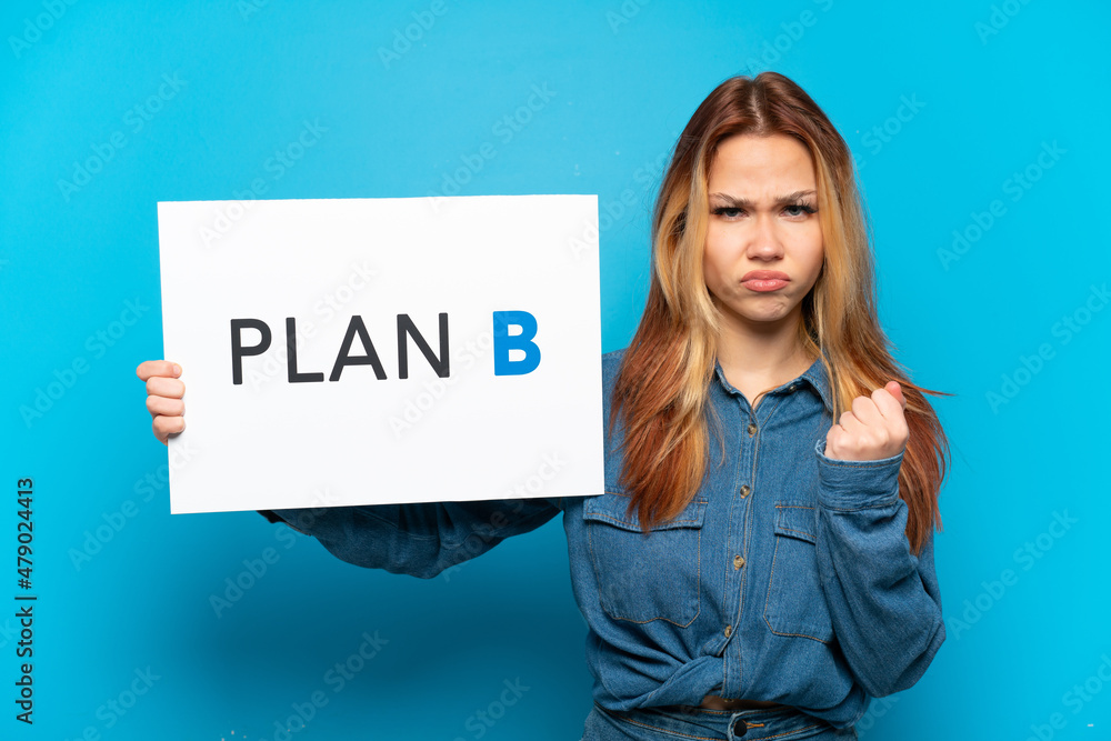 Teenager girl over isolated blue background holding a placard with the message PLAN B and angry Teenager girl over isolated blue background holding a placard with the message PLAN B and angry