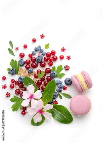 Fototapeta Naklejka Na Ścianę i Meble -  A scattering of juicy berries, flower and macarons.