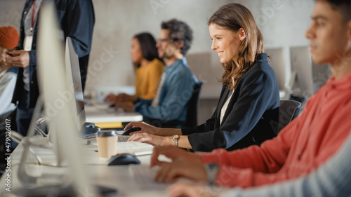 Beautiful Smart Female Student, Studying in Modern University with Diverse Multiethnic Classmates. Smiling College Scholars Work in College Room, Learning IT, Software Engineering or Computer Science.