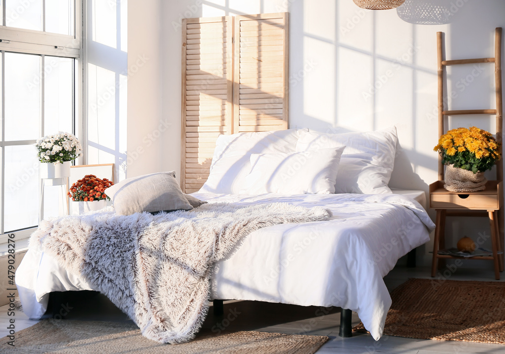 Fototapeta premium Interior of light bedroom with beautiful Chrysanthemum flowers