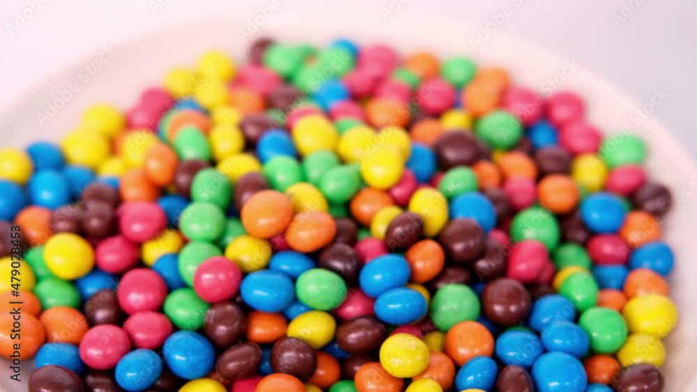 Frankfurt, Germany, October 2021: close-up of multi-colored button-shaped chocolates, each of which has letter Frankfurt, Germany, October 2021: close-up of multi-colored button-shaped chocolates, each of which has letter