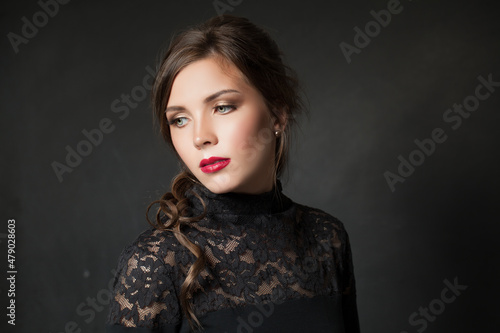 Pretty lady with makeup in black dress on black background
