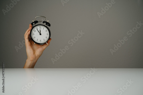 Hand holds black watch with grey background