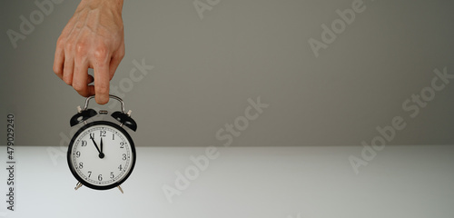 Hand holding black alarm clock