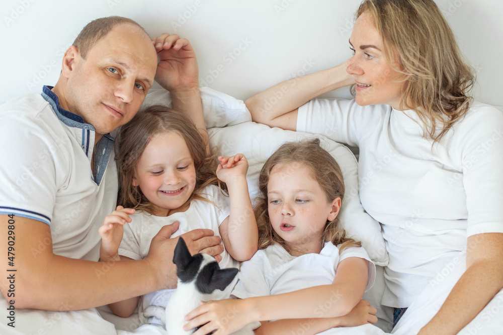Happy family lying down on bed at home