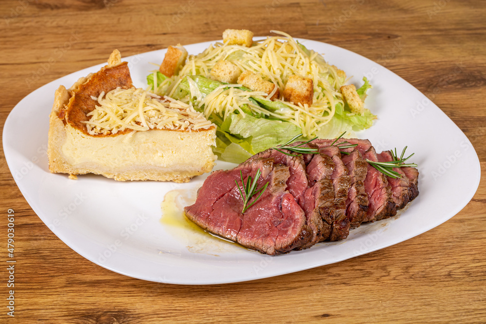 Roast beef served with caesar salad and slice of cheese quiche.healthy dish Roast beef served with caesar salad and slice of cheese quiche.healthy dish
