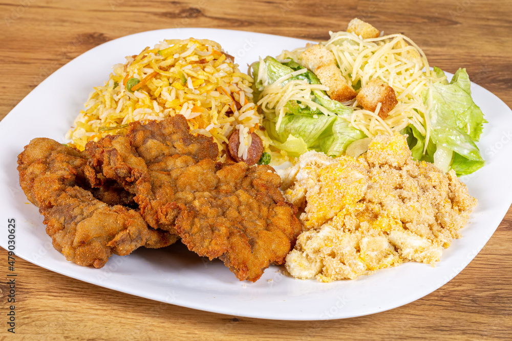 Breaded beef steak served with caesar salad, biro biro rice and egg farofa. Brazilian food usually served as an executive dish Breaded beef steak served with caesar salad, biro biro rice and egg farofa. Brazilian food usually served as an executive dish