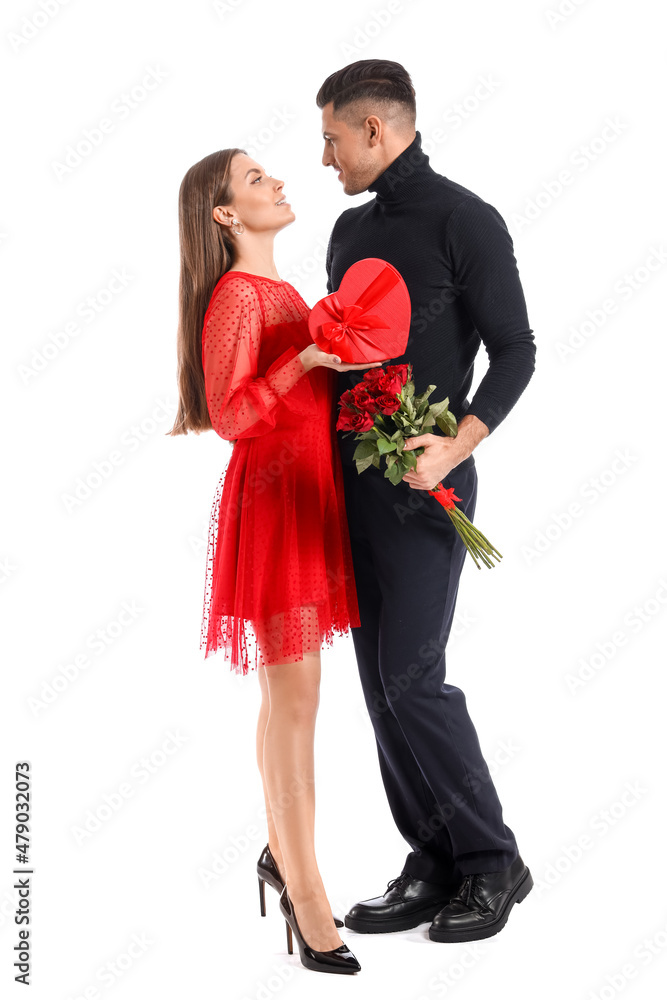 Happy young couple with gift and flowers on white background. Valentine's Day celebration Happy young couple with gift and flowers on white background. Valentine's Day celebration
