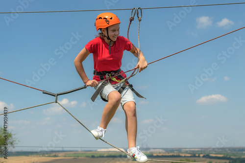 Girl on a cable car in a sports rope extreme park. © andov