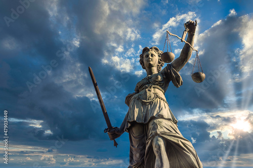 Justitia monument in Frankfurt roemerberg low angle during sunset on a cloudy day