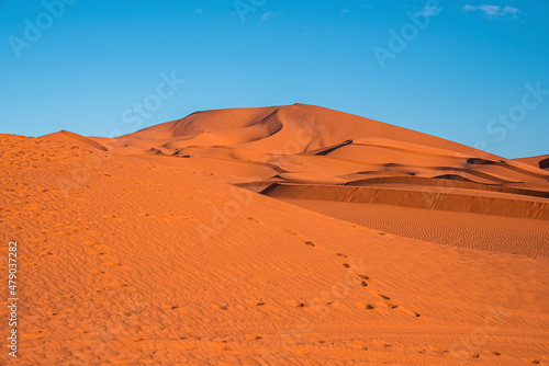 Beautiful view of footprints on sand dunes in sahara desert against clear sky  Footsteps on sand dunes in desert landscape