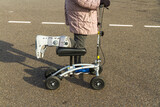 Woman with leg and foot  in surgical boot using a knee scooter walker landscape.