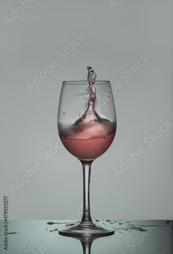 red wine splash. Rose wine glass where the liquid wants to come out of the glass in a splash.