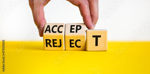 Accept or reject symbol. Businessman turns wooden cubes and changes the word reject to accept. Beautiful yellow table, white background, copy space. Business and accept or reject concept.