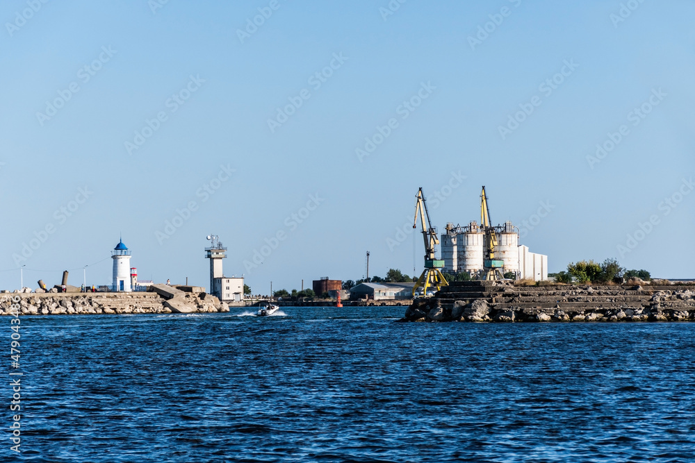  Genoves lighthouse and the industrial cranes and silos in the Mangalia harbor. Mangalia, Romania.