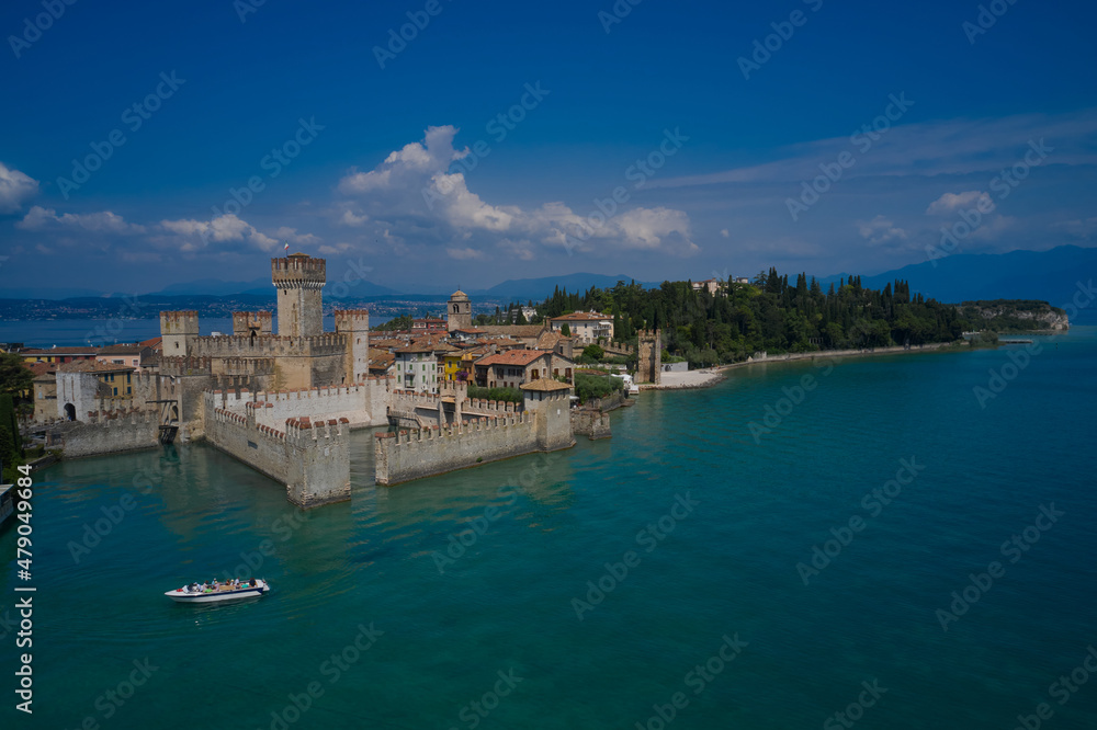 Sirmione, Lake Garda, Italy. Boat with tourists on an excursion near the main castle