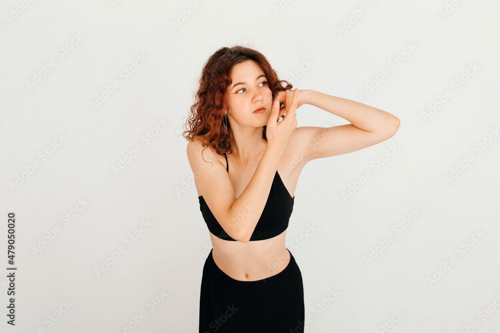 Naklejka premium Thoughtful cute redhead woman holding hands near her face, looking ti the side, standing over white background