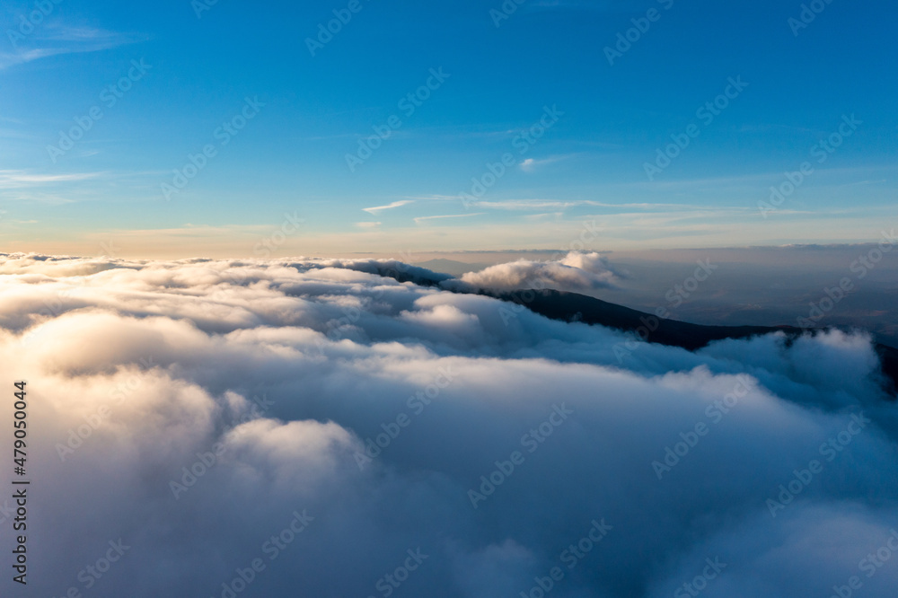 Thick layer of white clouds above mountains at sunrise Thick layer of white clouds above mountains at sunrise