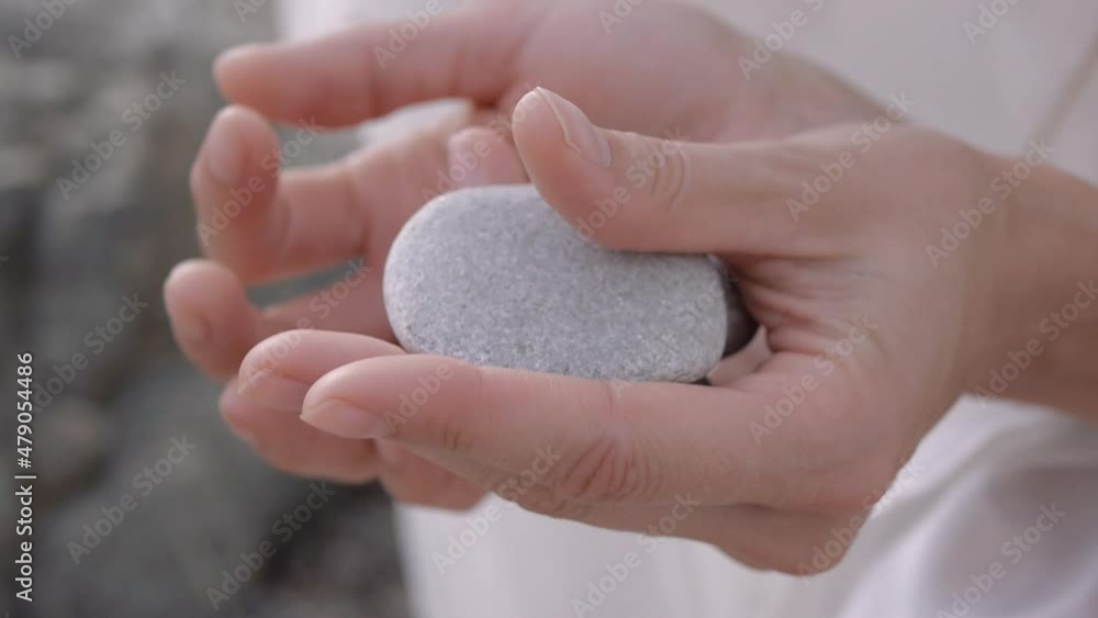 Woman plays with stone rolling the stone from palm to palm. Close-up. Woman plays with stone rolling the stone from palm to palm. Close-up.