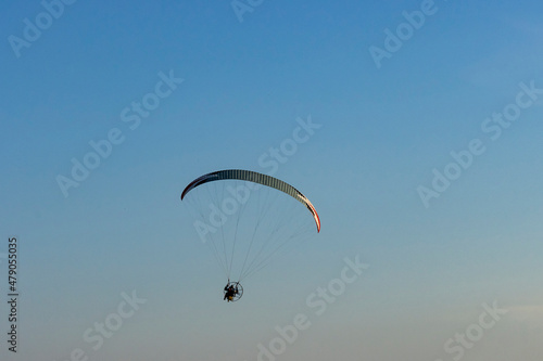 Paraglider with motor against blue sky