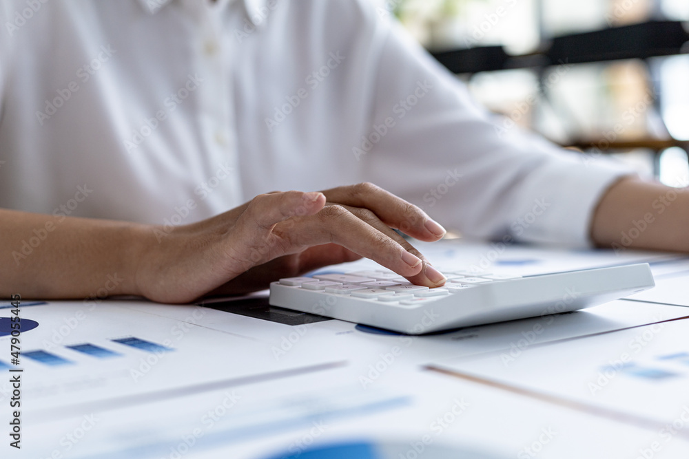 Fototapeta premium The company's finance manager is using a calculator, he uses a calculator to calculate the numbers in the company's financial documents that employees in the department create as meeting documents.