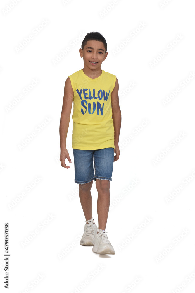 front view of a full portrait of a boy dressed in shorts and sleeveless walking on white background front view of a full portrait of a boy dressed in shorts and sleeveless walking on white background