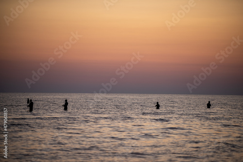 Pescatori al mare al tramonto.