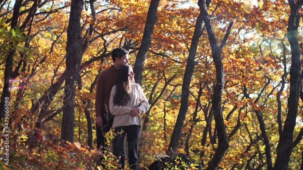 Young caucasian couple in love. Woman and man are embracing, smiling and enjoying each other in the beautiful park, yellow autumn trees on the background. Wonderful sunny day Young caucasian couple in love. Woman and man are embracing, smiling and enjoying each other in the beautiful park, yellow autumn trees on the background. Wonderful sunny day