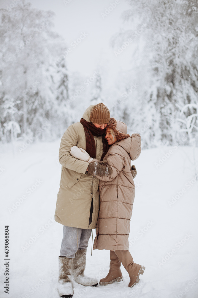 Loving couple hugging in the winter forest Loving couple hugging in the winter forest