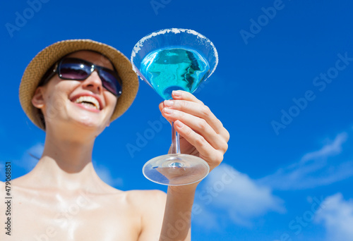 young happy woman enjoying a cocktail drink on a sunny summer day