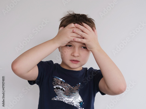 little boy holding his head. Child's headache