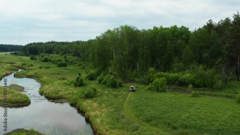 Aerial view of a car driving in nature near the river Aerial view of a car driving in nature near the river
