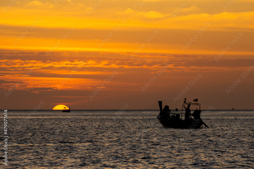 Long tail boat silhouetted against a fantastic sunset in Thailand