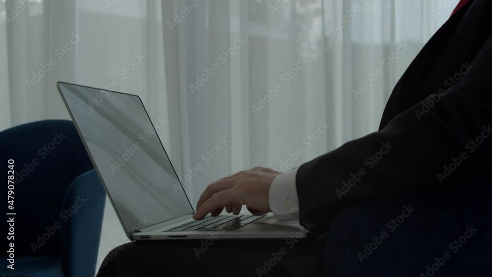 Businessman working on laptop computer in office lobby. Male professional typing on laptop keyboard at workplace in office. Portrait positive businessman looking laptop screen indoors Businessman working on laptop computer in office lobby. Male professional typing on laptop keyboard at workplace in office. Portrait positive businessman looking laptop screen indoors