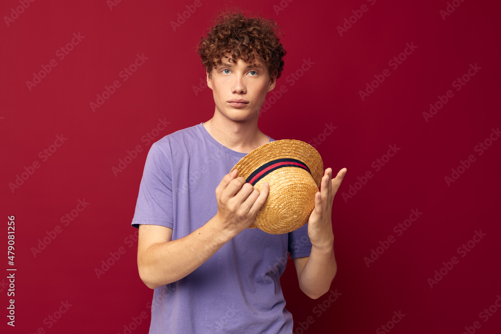 A young man fashion posing hand gestures stylish hat red background unaltered A young man fashion posing hand gestures stylish hat red background unaltered