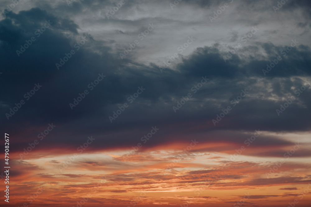 Dramatic clouded sky in beautiful sunset, with tones in blue and orange