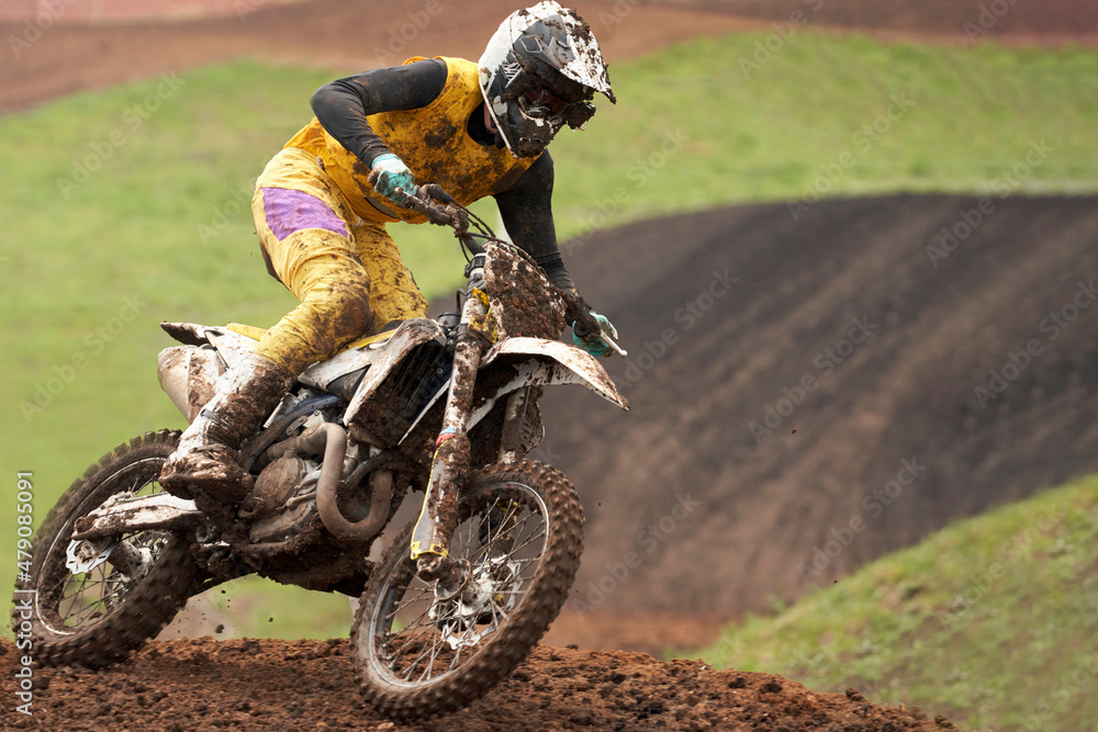Motorcycle racer in the mud close-up racing on a dirt track. Selective focus. Motorcycle racer in the mud close-up racing on a dirt track. Selective focus.