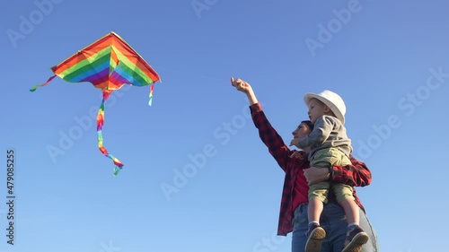 happy family launches a kite. happy childhood kid dream concept. mother and son playing with a kite in the park. fun family play kite flying in the sky. travel outside nature concept photo