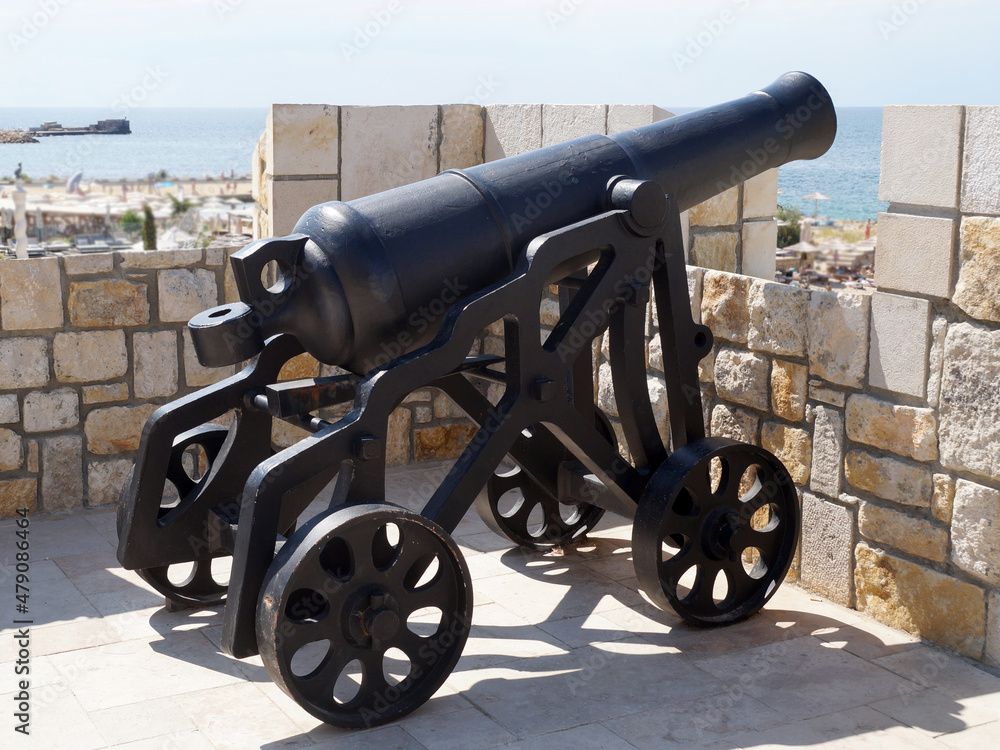 antique cannon aimed at the sea on the fortress wall