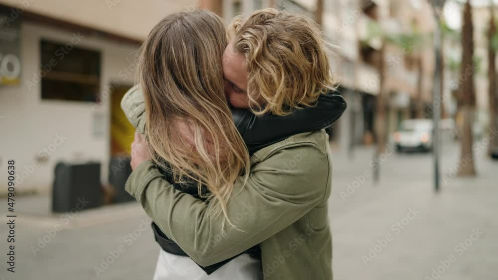Young caucasian couple smiling confident hugging each other standing at street Young caucasian couple smiling confident hugging each other standing at street