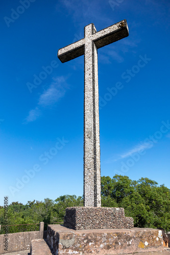 The Cruz Alta viewpoint is the higest point in the Bussaco range in Portugal. The cross monument is under a blue sky photo